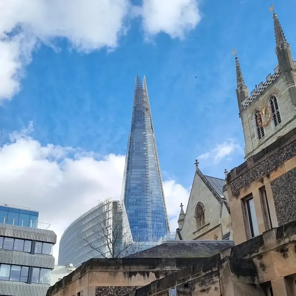 The Shard rising behind the stone tower of Southwark Cathedral