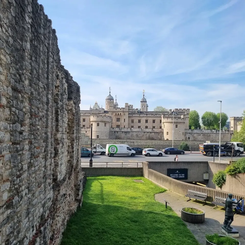 The Tower of London seen beyond a section of the old city wall