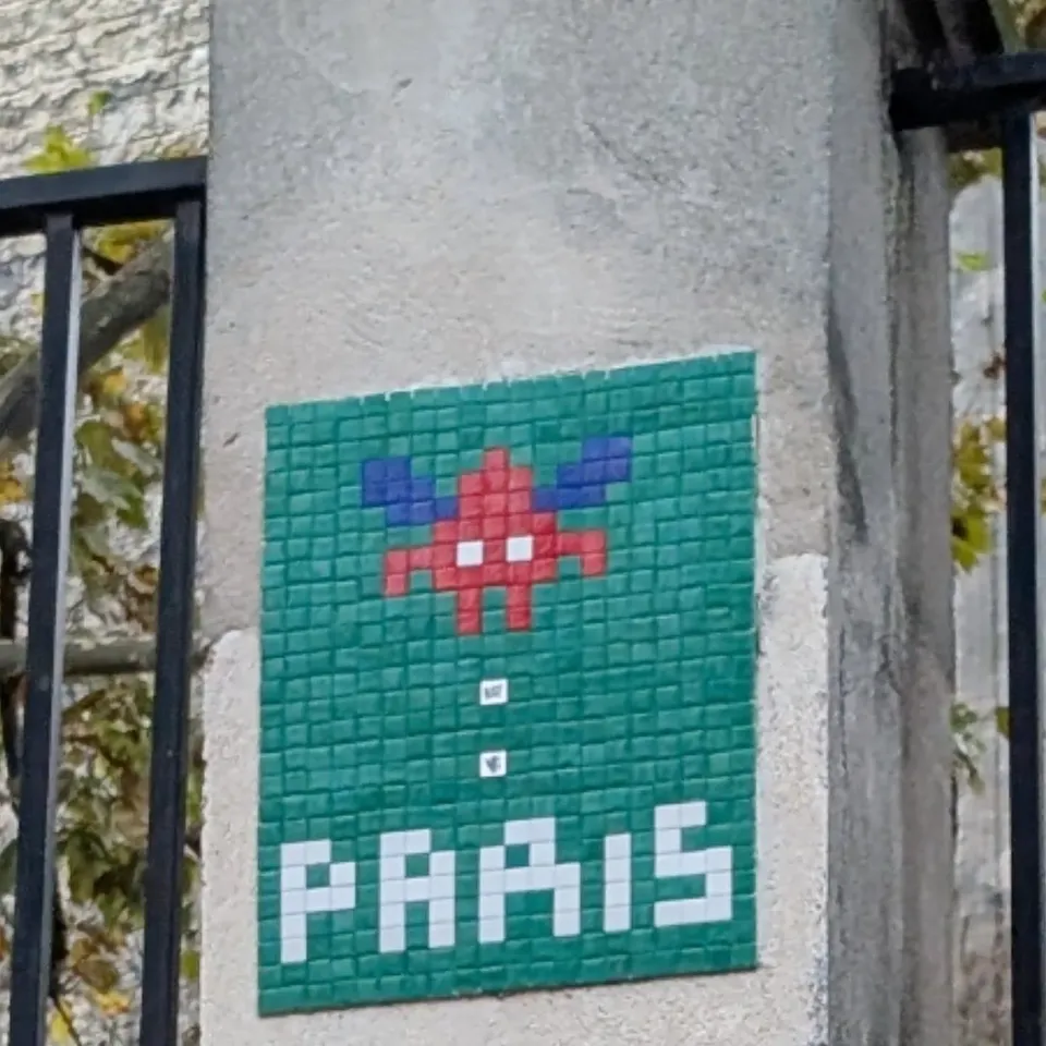 A green and pink Space Invader mosaic spelling out Paris