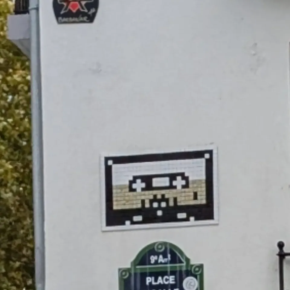 A small Space Invader mosaic above a Paris street sign